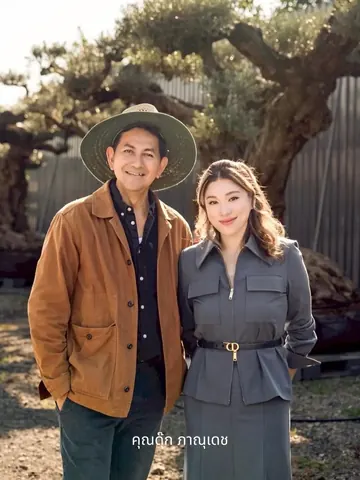 Duke Bhanudej and another person pose in front of a mature olive tree.