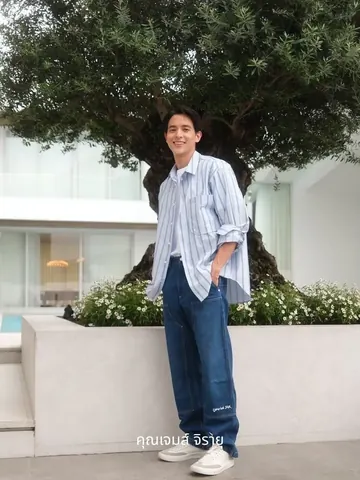 James Jirayu Tangsrisuk stands beneath a broad olive tree.
